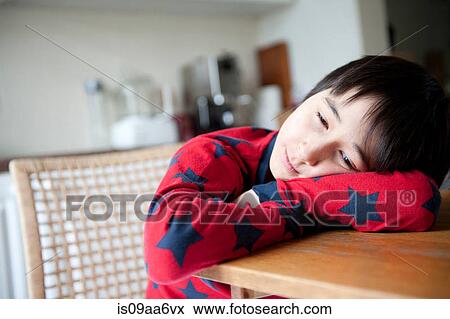 Boy in pyjamas resting on elbows on table View Large Photo Image Stock Photo - Boy in pyjamas resting on elbows on table. Fotosearch