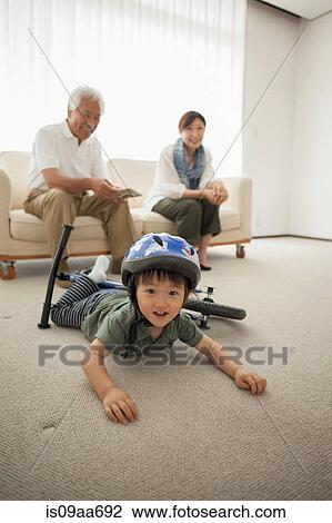 Boy lying on floor with bicycle View Large Photo Image Stock Image - Boy lying on floor with bicycle. Fotosearch