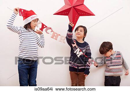 Children holding Christmas decorations View Large Photo Image Stock Image - Children holding Christmas decorations. Fotosearch
