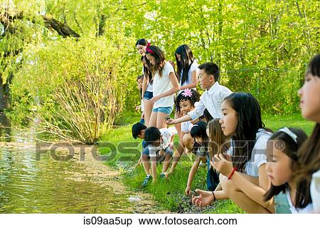 Stock Photography - Children playing by lake. Fotosearch