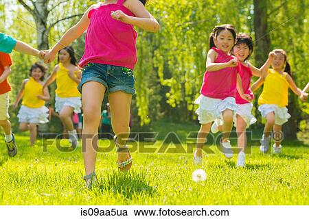 Stock Image - Children running on grass. Fotosearch