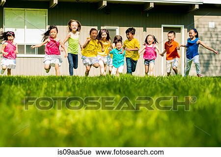 Stock Image - Children running on grass. Fotosearch