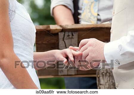 Close up of couple putting on rings at wedding ceremony View Large Photo Image Stock Photography - Close up of couple putting on rings at wedding ceremony. Fotosearch