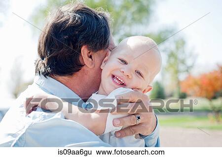 Stock Photograph - Close up of grandfather hugging grandson. Fotosearch