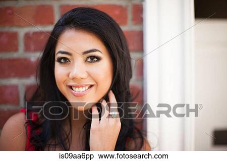 Stock Photography - Close up portrait of young woman outside front door. Fotosearch