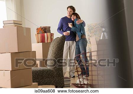 Couple having a drink break whilst moving View Large Photo Image Stock Photo - Couple having a drink break whilst moving. Fotosearch