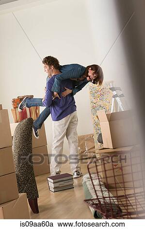 Stock Image - Couple having fooling about whilst moving. Fotosearch