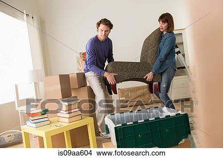 Couple lifting chair in house move View Large Photo Image Picture - Couple lifting chair in house move. Fotosearch