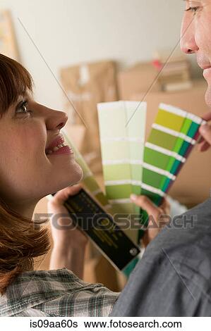 Couple looking at green swatch in new home View Large Photo Image Stock Photograph - Couple looking at green swatch in new home. Fotosearch