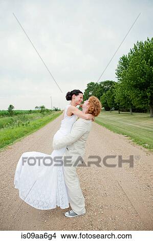 Couple on wedding day hugging on dirt track View Large Photo Image Picture - Couple on wedding day hugging on dirt track. Fotosearch