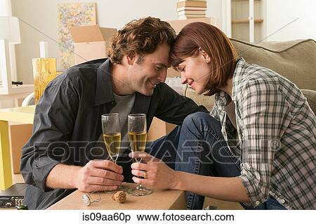 Stock Photography - Couple sharing champagne break whilst moving. Fotosearch