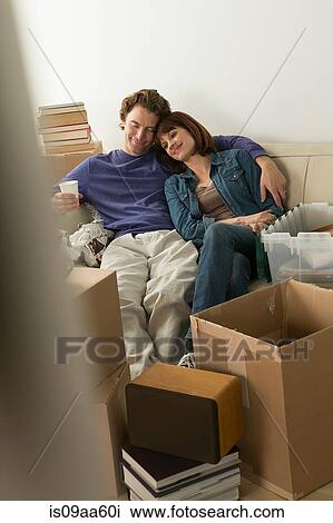 Stock Image - Couple taking a break whilst moving house. Fotosearch