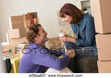 Couple taking a break whilst moving View Large Photo Image Stock Photo - Couple taking a break whilst moving. Fotosearch