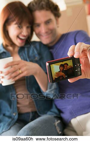 Couple taking self portrait whilst moving house View Large Photo Image Stock Image - Couple taking self portrait whilst moving house. Fotosearch