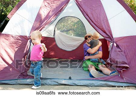 Stock Photograph - Father and toddler twins in tent. Fotosearch