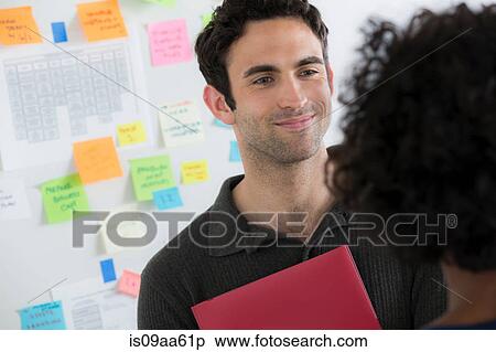 Stock Photography - Female and male office workers chatting. Fotosearch