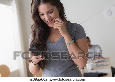 Female office worker looking at mobile phone View Large Photo Image Stock Photo - Female office worker looking at mobile phone. Fotosearch