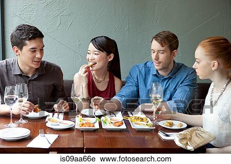 Four friends eating food in restaurant View Large Photo Image Stock Image - Four friends eating food in restaurant. Fotosearch