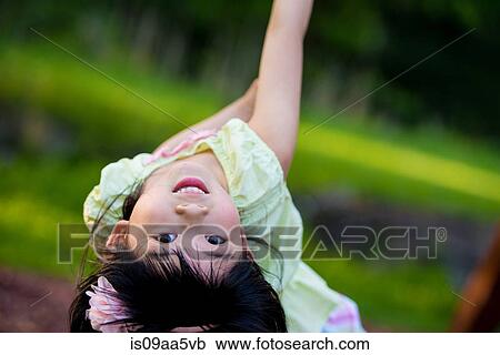Stock Image - Girl bending backwards looking at camera. Fotosearch