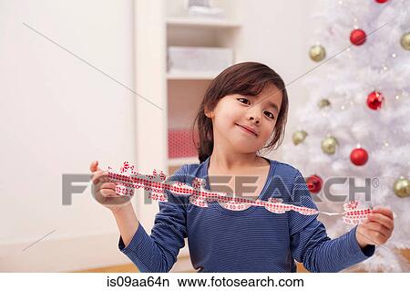 Picture - Girl holding Christmas decoration, portrait. Fotosearch
