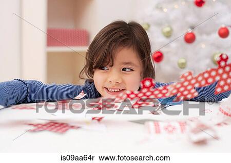 Stock Photography - Girl holding Christmas decoration, smiling. Fotosearch