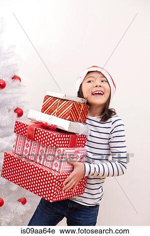 Girl holding Christmas gifts, smiling View Large Photo Image Stock Image - Girl holding Christmas gifts, smiling. Fotosearch