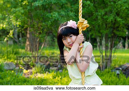 Stock Image - Girl on rope swing. Fotosearch