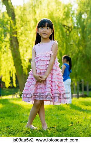 Stock Image - Girl wearing frilly pink dress. Fotosearch