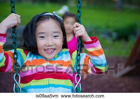 Picture - Girl wearing striped top on swing. Fotosearch