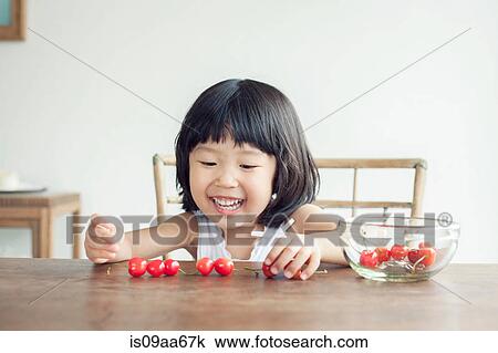 Stock Image - Girl with bowl of cherries. Fotosearch