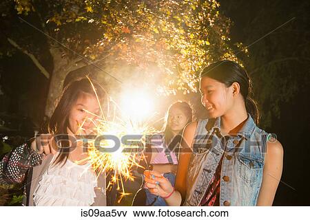 Stock Photo - Girl with sparkler at night. Fotosearch