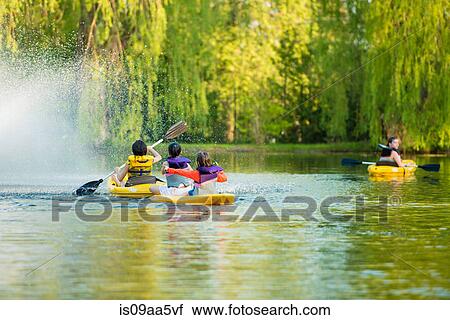 Stock Image - Girls canoeing on lake. Fotosearch