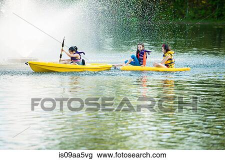 Girls canoeing on lake View Large Photo Image Stock Image - Girls canoeing on lake. Fotosearch