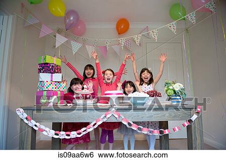 Stock Photograph - Girls cheering at birthday party. Fotosearch