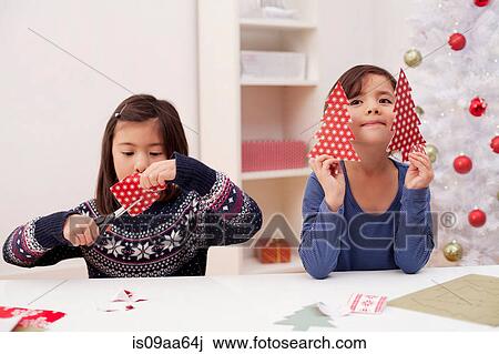 Girls holding and making Christmas decorations View Large Photo Image Stock Image - Girls holding and making Christmas decorations. Fotosearch
