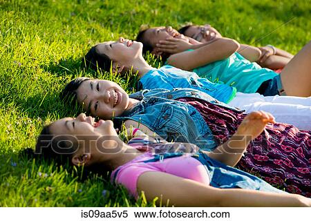 Stock Photography - Girls lying on grass. Fotosearch