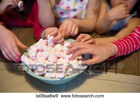 Girls reaching for sweets, close up View Large Photo Image Stock Photo - Girls reaching for sweets, close up. Fotosearch
