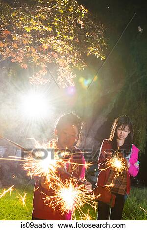 Girls with sparklers at night View Large Photo Image Stock Photograph - Girls with sparklers at night. Fotosearch