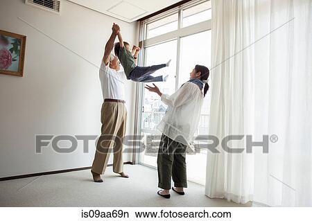 Grandfather and mother swinging young boy View Large Photo Image Picture - Grandfather and mother swinging young boy. Fotosearch
