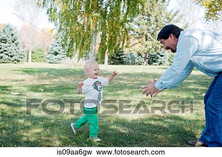 Stock Photo - Grandfather playing with grandson in park. Fotosearch