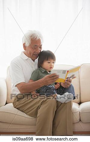 Stock Photo - Grandfather reading to grandson. Fotosearch