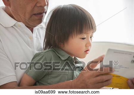 Stock Photo - Grandfather reading to grandson. Fotosearch