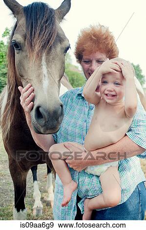 Stock Photo - Grandmother and toddler with pony. Fotosearch