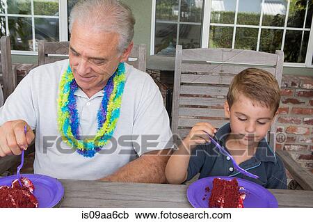 Grandson and senior man eating birthday cake View Large Photo Image Stock Image - Grandson and senior man eating birthday cake. Fotosearch