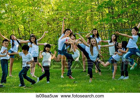 Stock Photo - Large group of children dancing in park. Fotosearch
