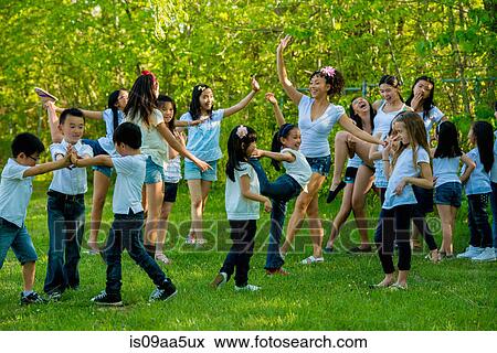 Stock Photo - Large group of children dancing in park. Fotosearch