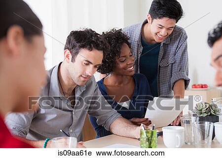 Stock Image - Male and female colleagues meeting in office. Fotosearch