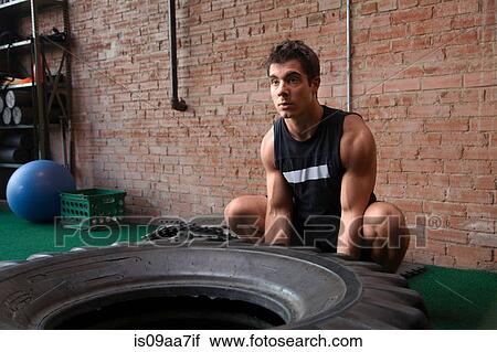 Male bodybuilder lifting tyre in gym View Large Photo Image Stock Image - Male bodybuilder lifting tyre in gym. Fotosearch