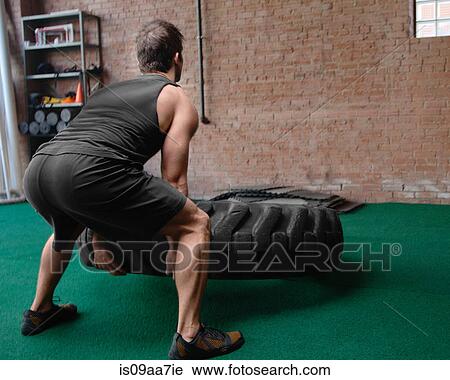 Male bodybuilder lifting tyre View Large Photo Image Stock Image - Male bodybuilder lifting tyre. Fotosearch