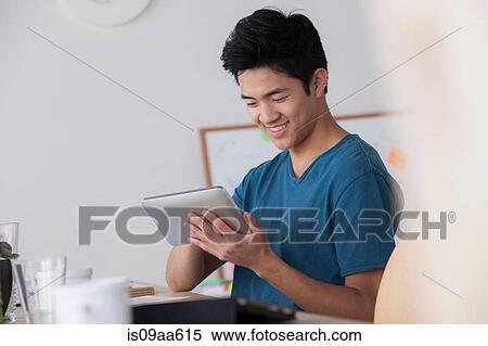 Stock Photography - Male office worker using digital tablet. Fotosearch